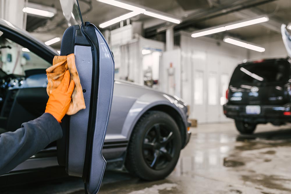 City Auto Body technician detailing a repaired vehicle in the Grand Haven shop